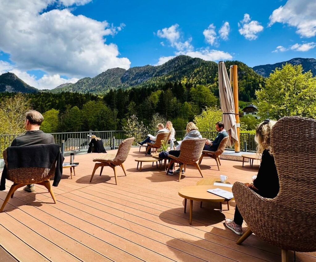Eine Terasse mit Menschen und Blick zum Grundlsee