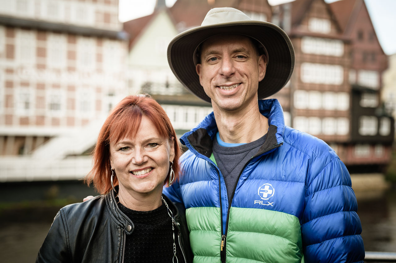 Eine Frau mit kurzen roten Haaren und ein Mann mit großem Hut